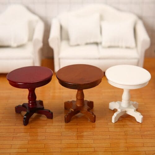 Three small wooden tables in front of a white couch.